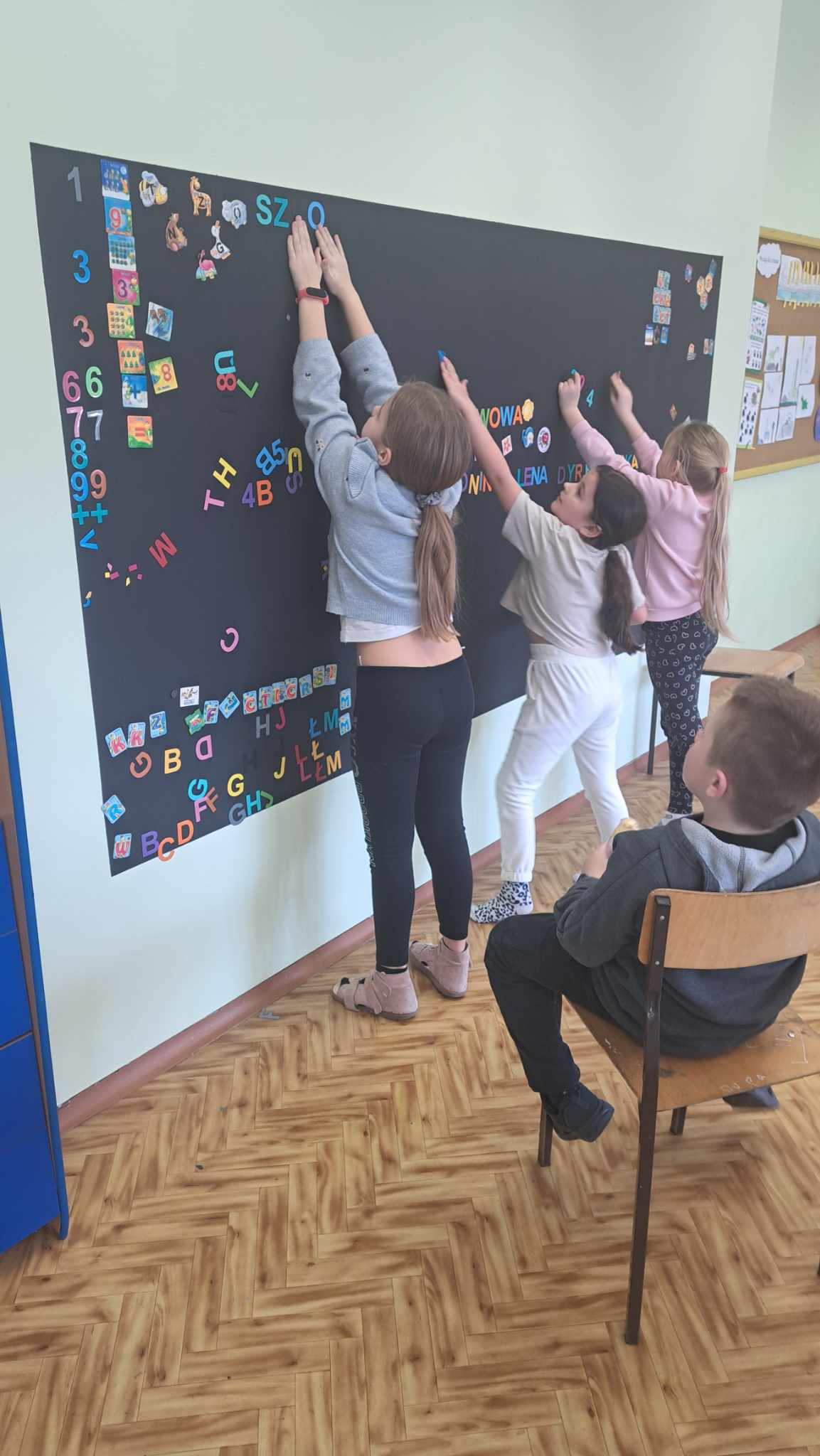 Dzieci układają literki na tablicy 