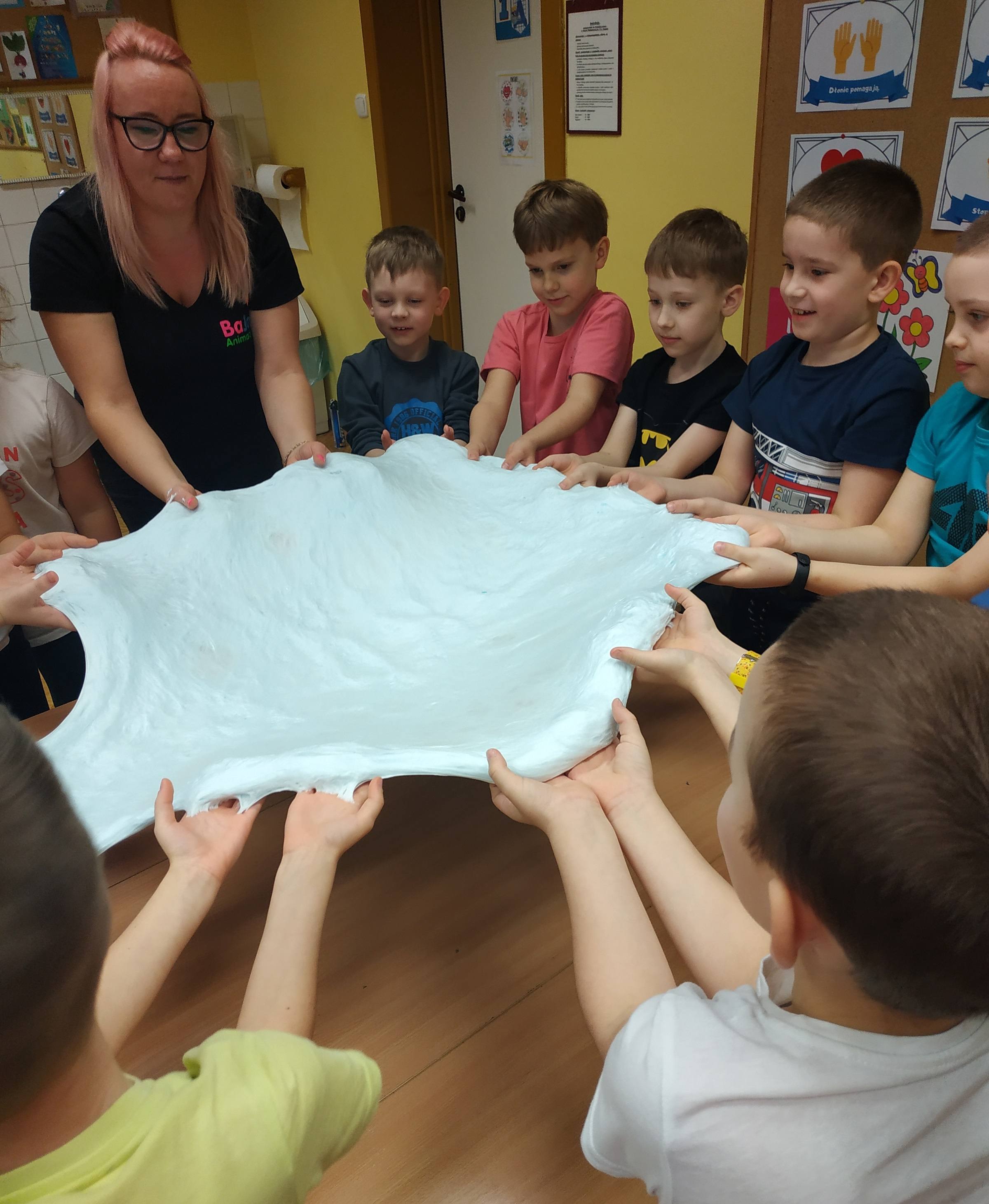 Dzieci rozciągają ciasto podczas zajęć plastycznych