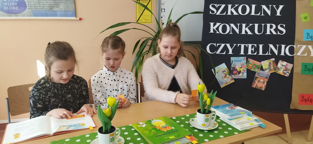 Trójka dzieci siedząca przy stoliku podczas konkursu