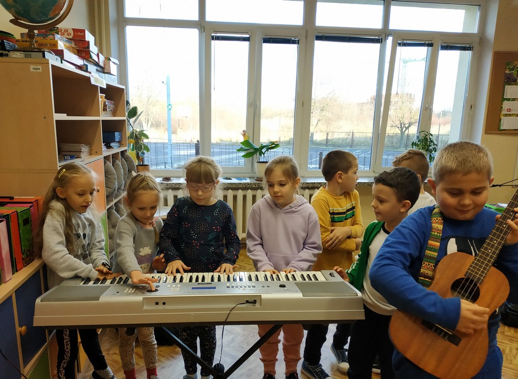 Grupa dzieci stojąca przy keyboardzie