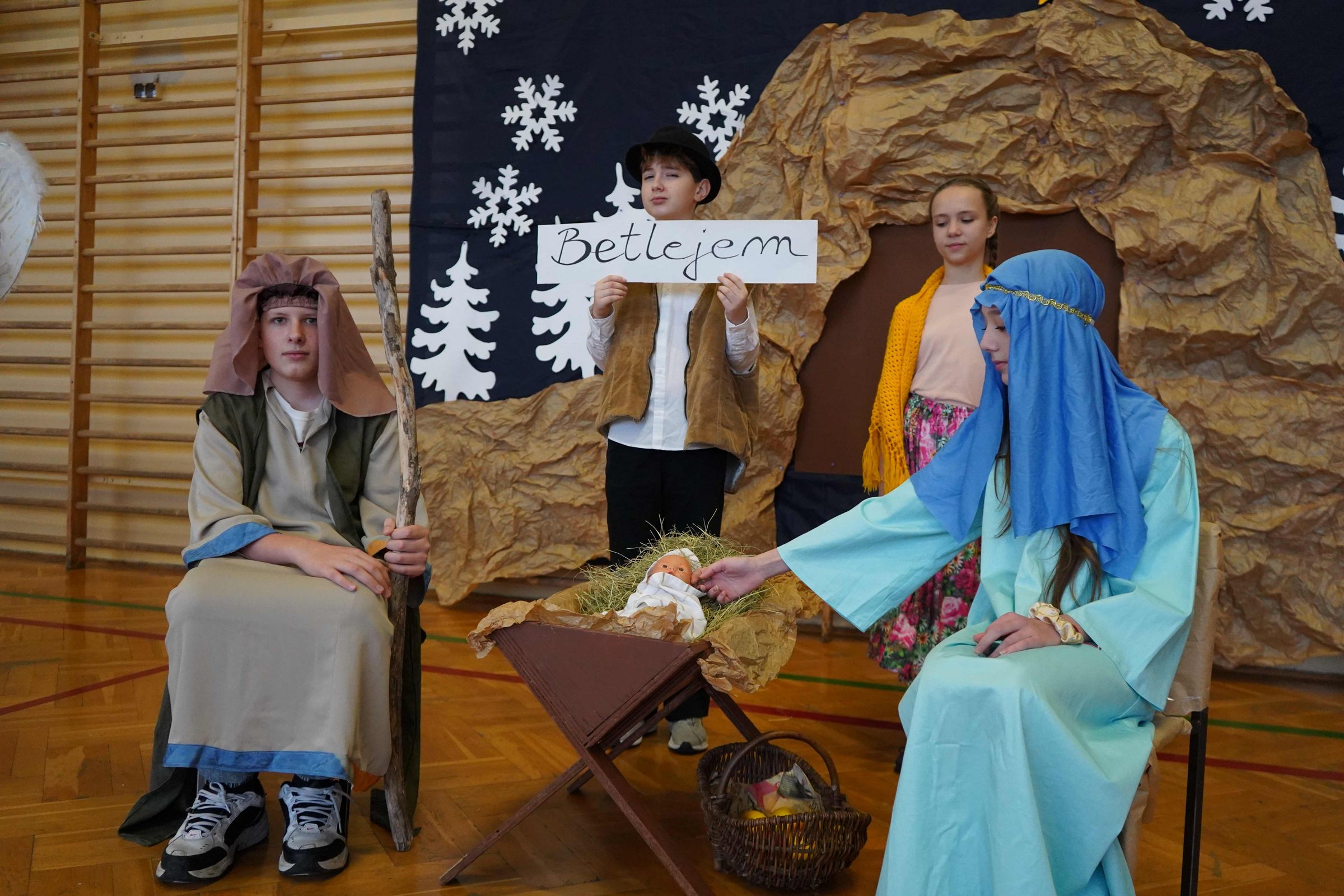 Józef z Maryją siedzą obok żłóbka